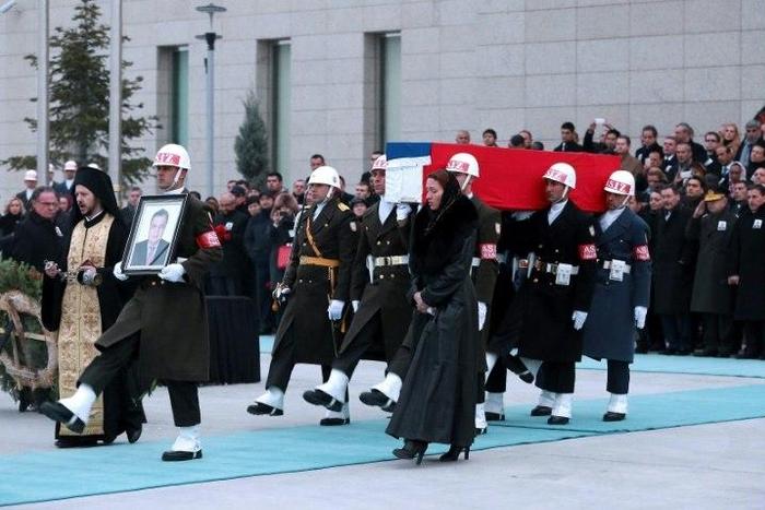 Members of a Turkish forces honour guard carry the Russian flag-draped coffin of late Russian Ambassador to Turkey Andrei Karlov and a picture of him during a ceremonial farewell with full state honours on the tarmac of Ankara's Esenboga Airport