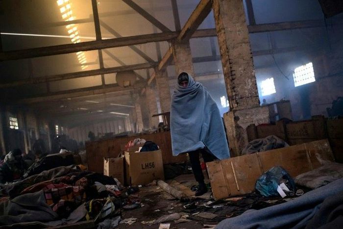 A migrant walks trough a makeshift shelter at an abandoned warehouse in Belgrade, Serbia, on December 8, 2016