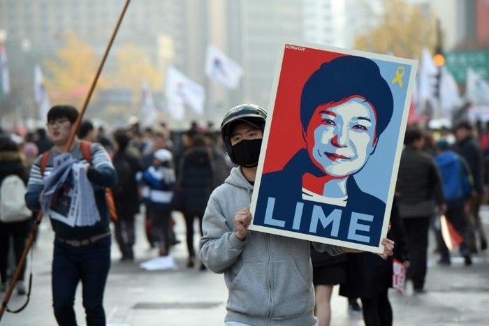 A protester holds a placard with a portrait of South Korea's President Park Geun-Hye, during an anti-government rally in Seoul
