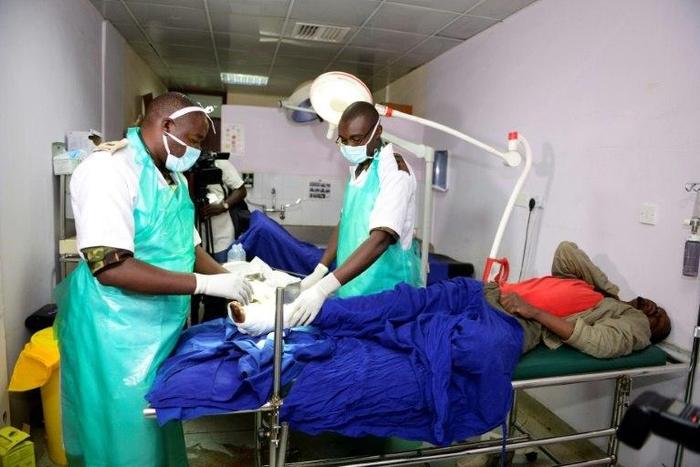 Kenyan Defence Force (KDF) doctors tend to an injured man at Kenyatta National Hospital in Nairobi on December 10, 2016, after being deployed during a five-day strike