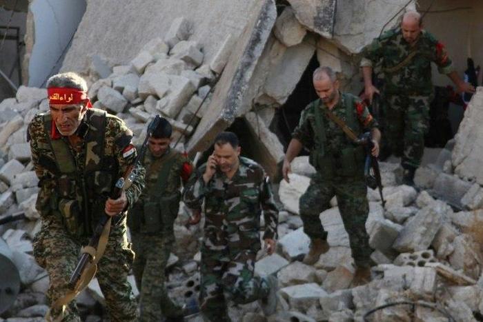 Syrian pro-government soldiers patrol the Uwaija neighborhood as they advance in Aleppo's rebel-held areas