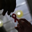 A nurse (L) hands out a red ribbon to a woman, to mark World Aids Day, at the entrance of Emilio Ribas Hospital, in Sao Paulo December 1, 2014. REUTERS/Nacho Doce