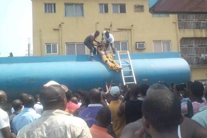 Two men are seen bringing out the corpse of Emmanuel from the petrol tanker.