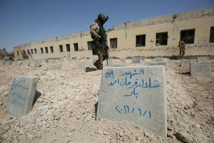 Iraqi soldiers check a cemetery where jihadists of the Islamic State (IS) group were buried in Fallujah