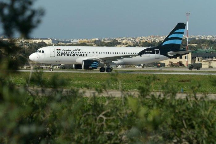 A picture taken on December 23, 2016 shows a Malta armed forces truck sitting by the Afriqiyah Airways A320 after it landed in Valletta, Malta, following its hijacking from Libya