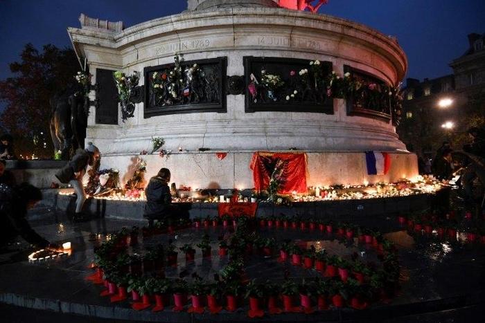 People light candles at a makeshit memorial at the bottom of the Marianne statue on place de la Republique in Paris on November 13, 2016