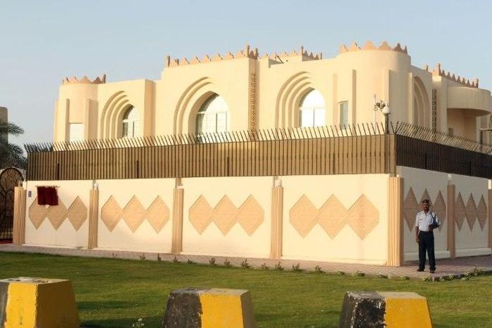 Security guards stand outside the Taliban political office in the Qatari capital Doha