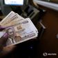 A teller counts Kenya shilling notes inside the cashier's booth at a forex exchange bureau in Kenya's capital Nairobi, April 20, 2016. REUTERS/Thomas Mukoya