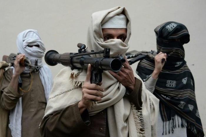 Former Afghan Taliban fighters carry their weapons before handing them over as part of a government peace and reconciliation process, in Jalalabad, in January 2016