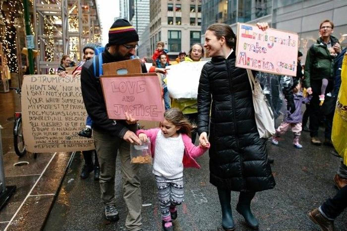 A family takes part in a protest march towards Trump Tower in New York to mark International Migrants Day