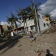 A woman walks along a street damaged by the heavy rains after the passing of Hurricane Patricia in Barra de Navidad, Mexico October 24, 2015.