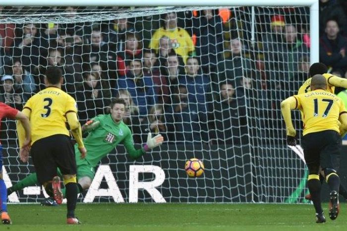 Watford's English striker Troy Deeney (R) scores their penalty past Crystal Palace's Welsh goalkeeper Wayne Hennessey (C) during their English Premier League football match on December 26, 2016