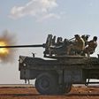 Fighters from the Free Syrian Army fire an anti-aircraft machine gun mounted on a vehicle as they battle the Islamic State (IS) group jihadists in the northern Syrian village of Yahmoul, on October 10, 2016