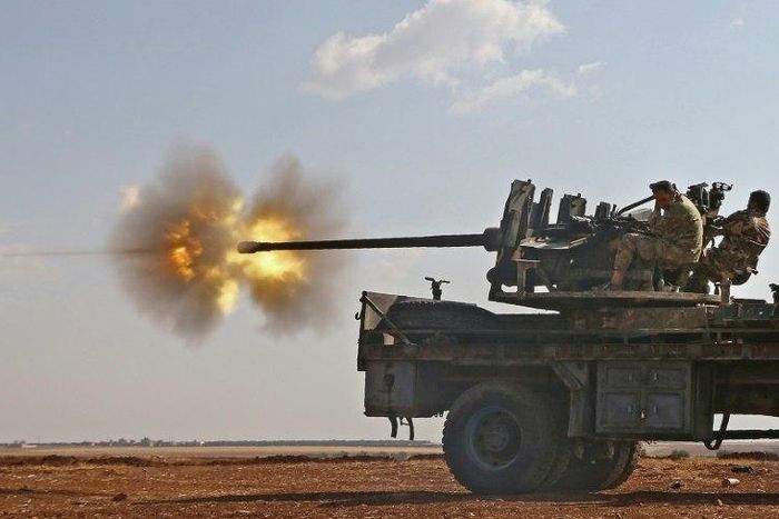 Fighters from the Free Syrian Army fire an anti-aircraft machine gun mounted on a vehicle as they battle the Islamic State (IS) group jihadists in the northern Syrian village of Yahmoul, on October 10, 2016