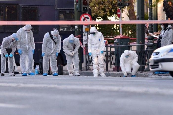 Police officers conduct a search at the front of the French embassy after two motorcyclists threw a hand grenade injuring the guard in central Athens on November 10, 2016