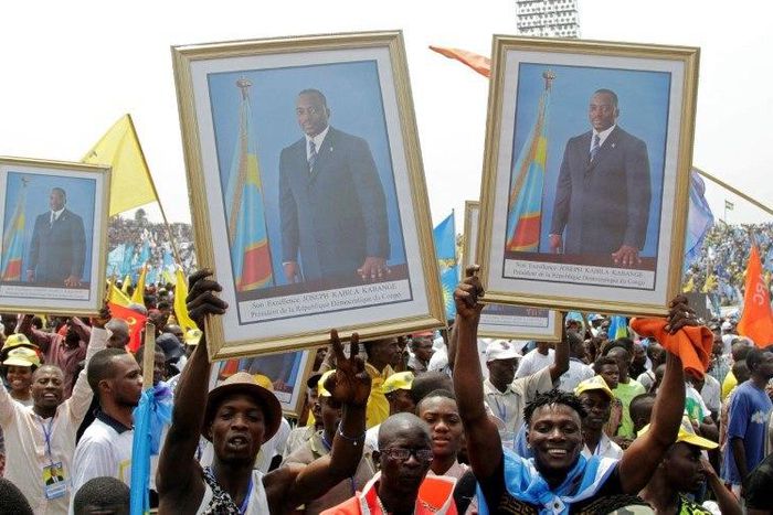 Supporters of Congolese President Kabila carry his portrait photographs during a pro-government rally in Kinshasa