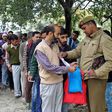 A policeman checks an identity card of a passenger at a checkpoint amid tightened security.
