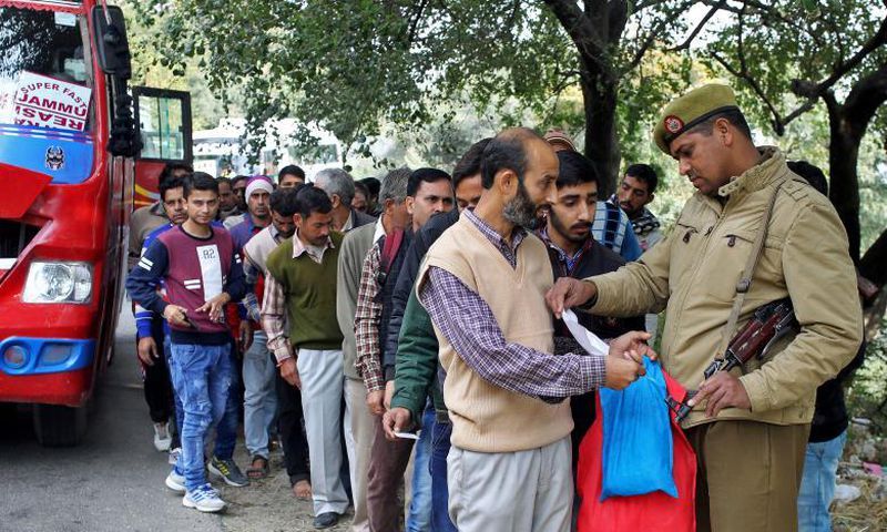 A policeman checks an identity card of a passenger at a checkpoint amid tightened security.