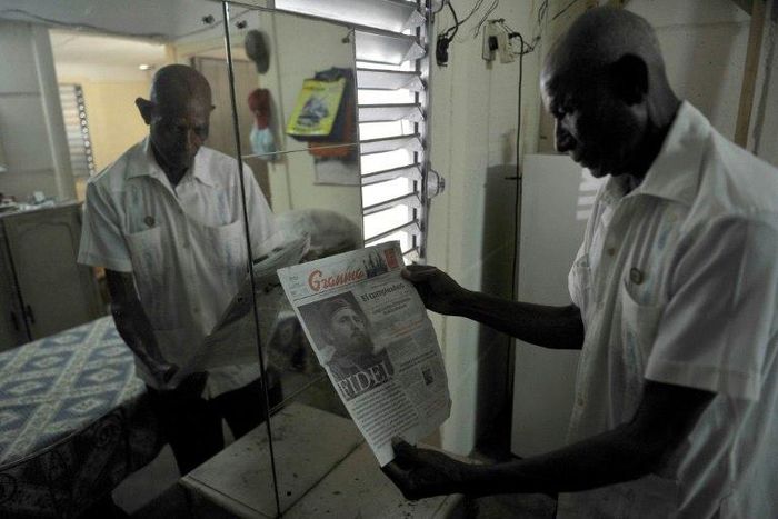 Luis Monteagudo Arteaga, a Cuban former guerrilla fighter, who joined Argentinean guerrilla leader Che Guevara in Congo, holds a newspaper with the frontpage dedicated to late Cuban revolutionary leader Fidel Castro at his home November 30, 2016