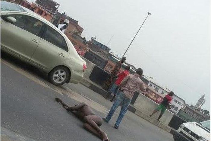 Man strips and lies down in the middle of major road