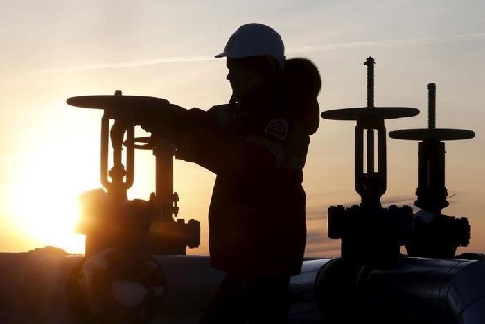 Worker checks valve of oil pipe at Lukoil company owned Imilorskoye oil field outside West Siberian city of Kogalym