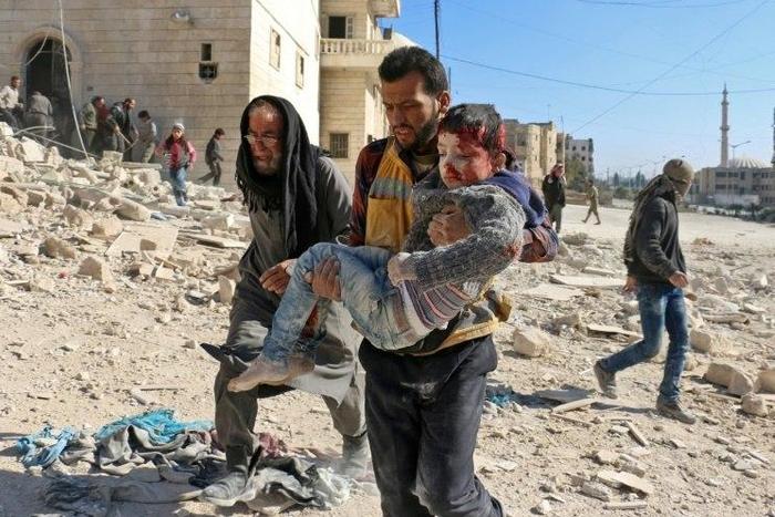 A Syrian civil defence volunteer, known as the White Helmets, carries a boy rescued from the rubble following a reported barrel bomb attack on the Bab al-Nairab neighbourhood of the northern Syrian city of Aleppo on November 24, 2016