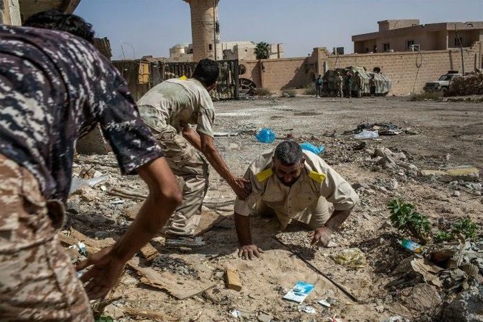 Fighters loyal to Libya's Government of National Accord help a wounded comrade after he was shot by an Islamic State group sniper on the western frontline in Sirte on October 2, 2016