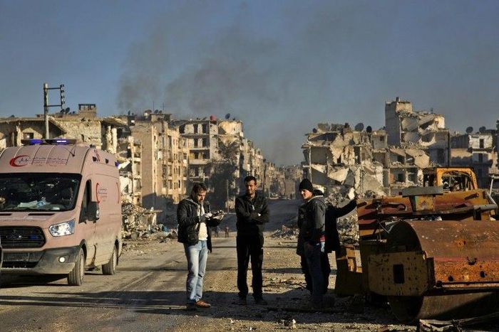 Syrians gather at the rebel-held al-Amiriyah neighbourhood as they wait to be evacuated to the government-controlled area of Ramoussa on the southern outskirts of Aleppo on December 15, 2016