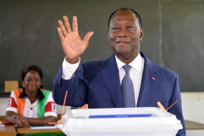 Ivory Coast's President Alassane Ouattara gestures after casting his vote in the ballot box, at a polling station in Abidjan, on October 30, 2016, during a vote for a referendum on a new constitution
