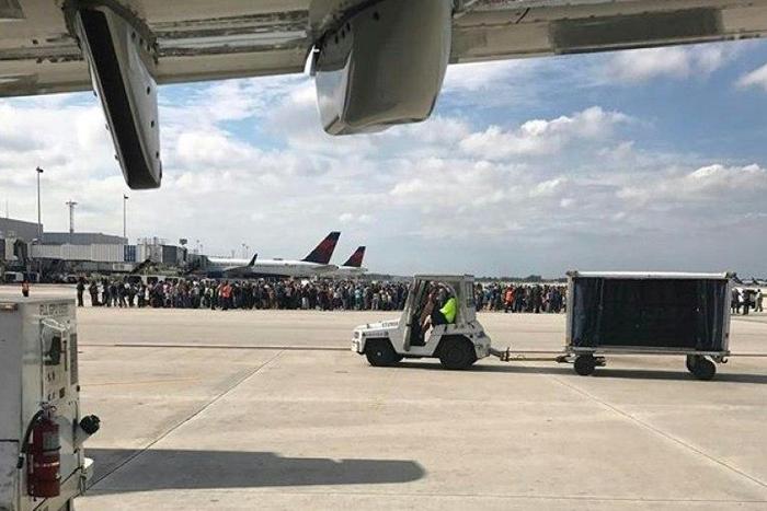 Passengers gather on the tarmac of the Fort Lauderdale-Hollywood airport in Florida after a gunman opened fire, killing five people and injuring 8 on January 06, 2017