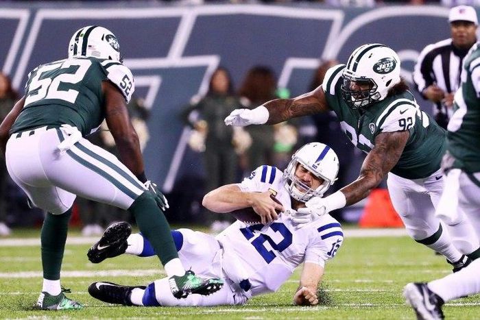 Andrew Luck of the Indianapolis Colts slides down against the New York Jets' defense of Leonard Williams and David Harris at MetLife Stadium