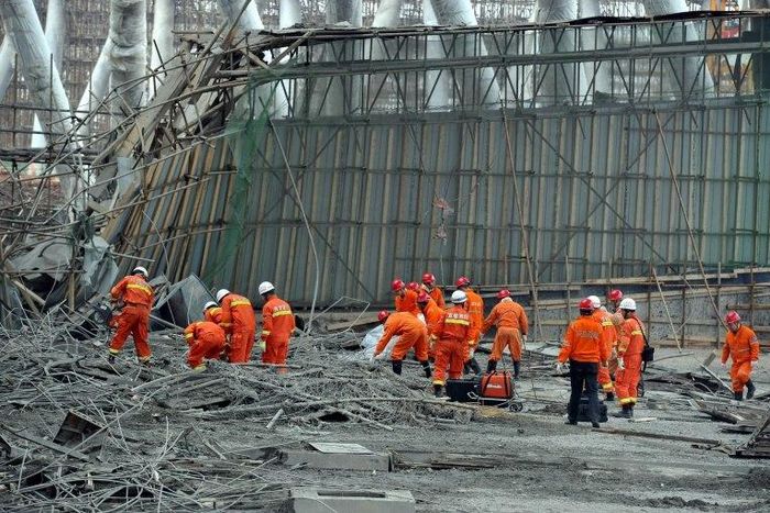 Workers search for survivors in the debris of a collapsed platform in a cooling tower at a power station at Fengcheng, in China's Jiangxi province, on November 24, 2016