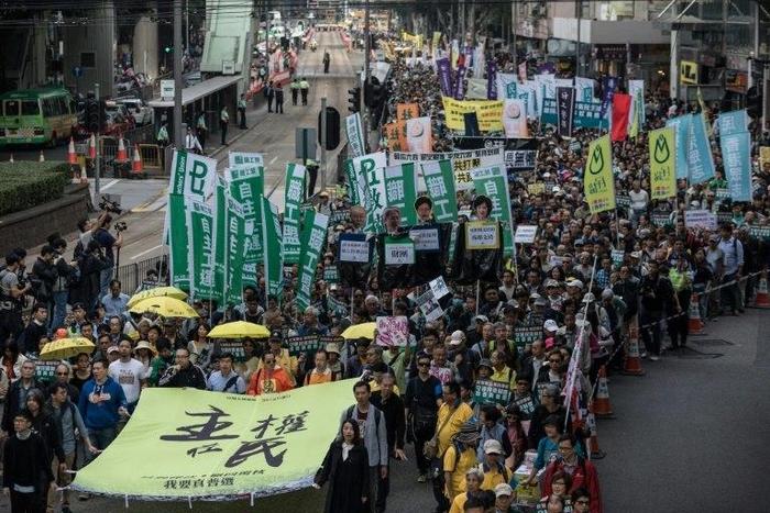 Protesters including pro-democracy lawmakers Lau Siu-lai (bottom C), Edward Yiu (behind Lau) and Nathan Law (bottom L) carry a banner reading "Sovereignty belongs to the people!" during a New Year's Day rally in Hong Kong on January 1, 2017