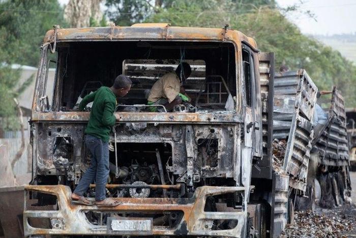 Children explore the remains of a cargo truck in Sebeta, central Ethiopia on October 13, 2016 after protesters took to the street to vandalise property thought to belong to the government
