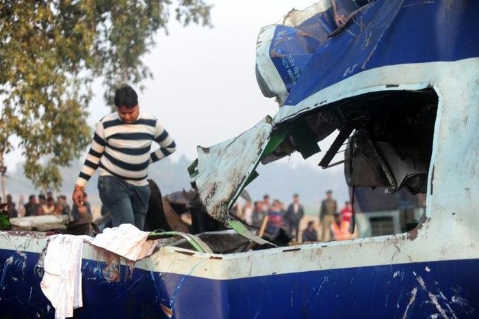 A relative attempts to identify luggage of a family member who was killed when a train derailed near Kanpur in the northern Indian state of Uttar Pradesh on November 20, 2016