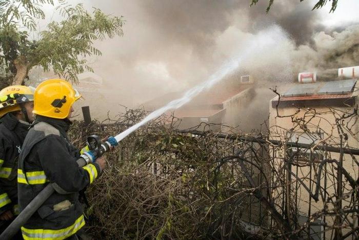 Israeli firefighters help extinguish a fire in the northern Israeli port city of Haifa on November 24, 2016