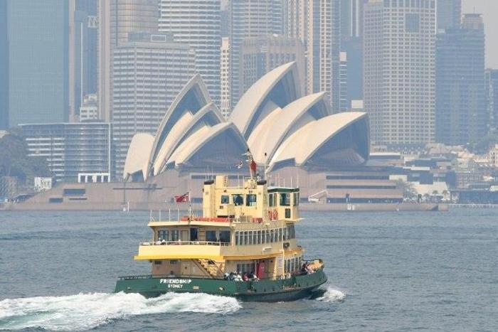 A ferry heads toward Sydney's Circular Quay as the city is shrouded in smoke