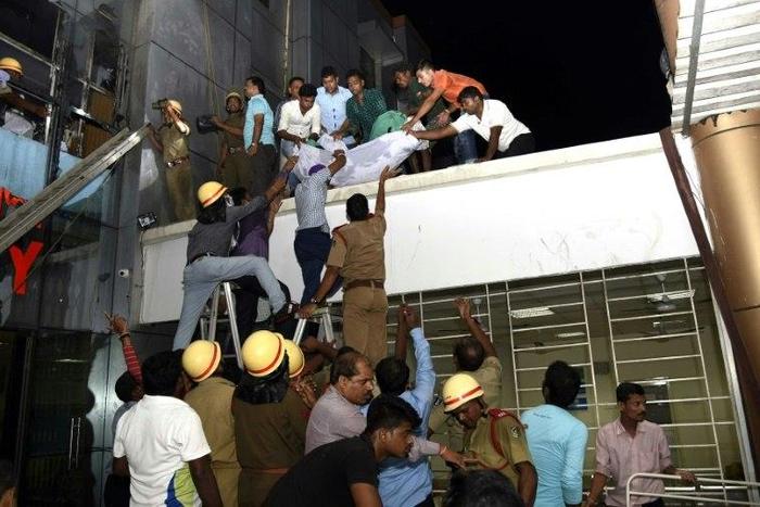 Rescue workers lower the body of a victim of a massive fire at the SUM hospital building in Bhubaneswar, the capital of eastern India's coastal Odisha state, on October 17, 2016