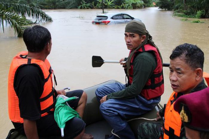 Rescue workers ride a boat as they patrol an area flooded in Sichon District, Nakhon Si Thammarat province, Thailand December 3, 2016.