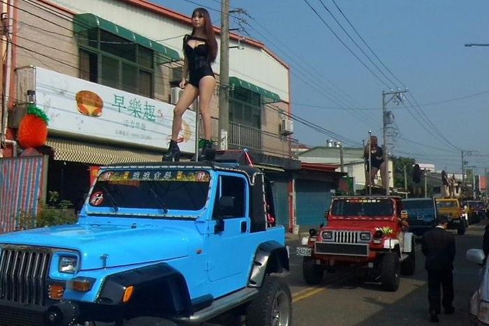 Pole dancers perform on top of jeeps during the funeral procession of former Chiayi City county council speaker Tung Hsiang in Chiayi City, southern Taiwan on January 3, 2017