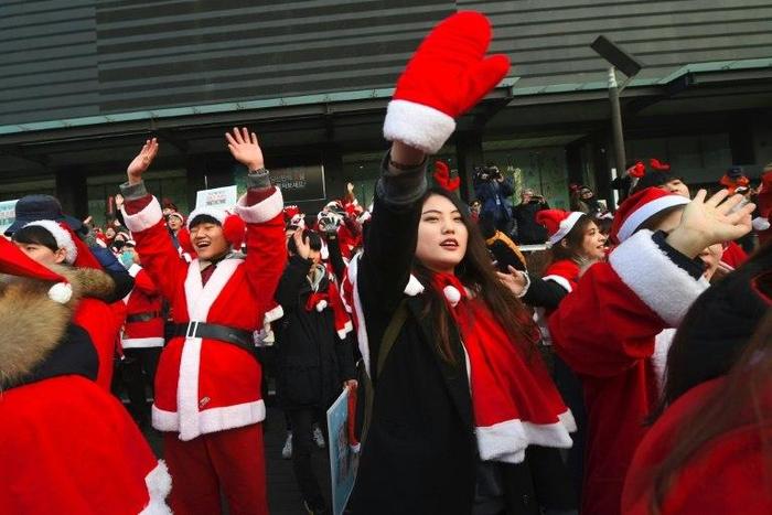 Protesters wearing Santa Claus outfits attend a rally calling for the immediate removal of South Korea's impeached president Park Geun-Hye in downtown Seoul on December 24, 2016