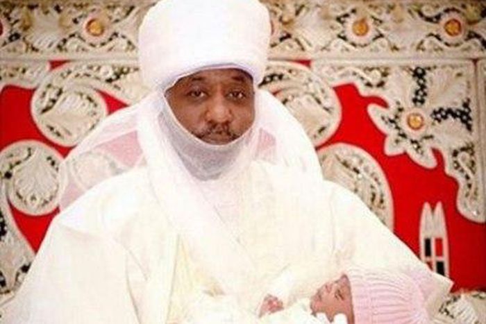 The Emir of Kano is seen holding his grand-daughter.