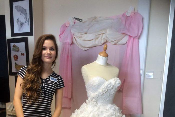 Rachel stands beside her impressive work