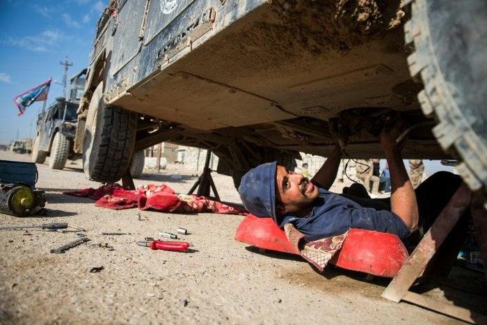 Iraqi army mechanic Hussein works on a Humvee vehicle in Mosul, on November 17, 2016