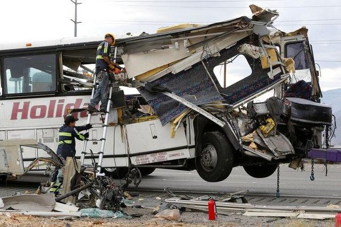 Workers cut away debris from the front of a bus involved in a mass casualty crash on the westbound Interstate 10 freeway near Palm Springs, California October 23, 2016.