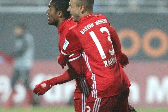 Bayern Munich's midfielder Douglas Costa celebrates after scoring with Rafinha in Darmstadt, Germany, on December 18, 2016