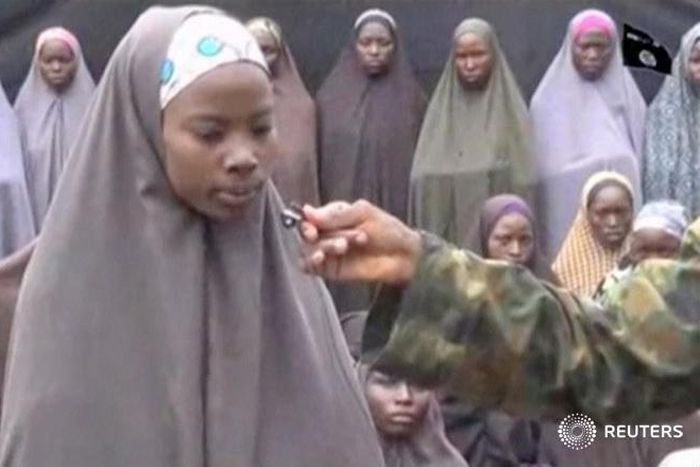 A still image from a video posted by Nigerian Islamist militant group Boko Haram on social media and seen by Reuters on August 14, 2016, shows a girl who identified herself to a masked man as Maina Yakubu and that she is from Chibok, as dozens of other...