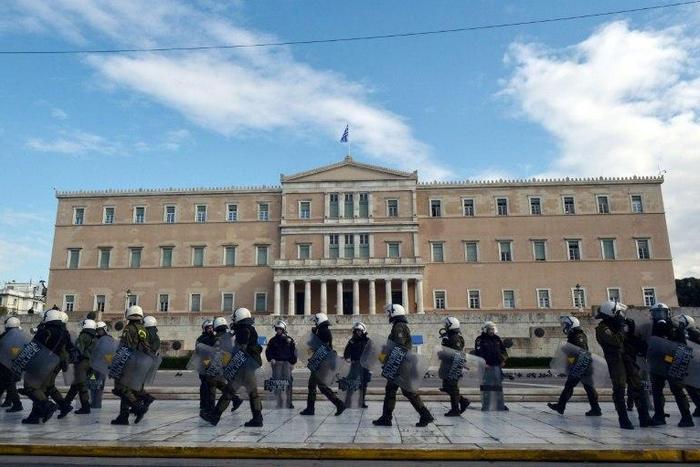Greek police stand guard outside the parliament building in Athens during a protest on December 6, 2016