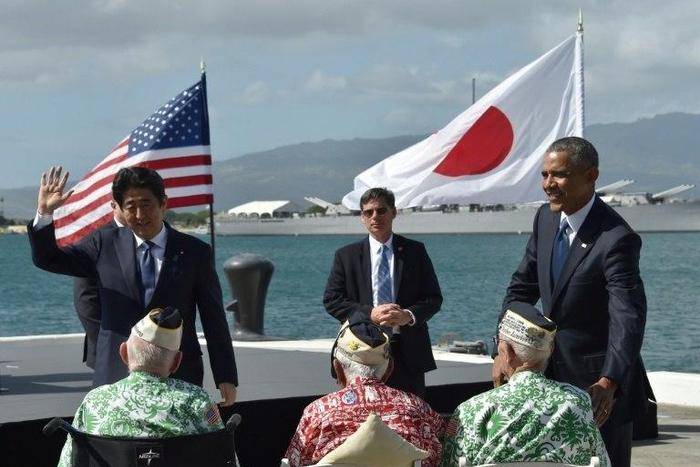 US President Barack Obama and Japanese Prime Minister Shinzo Abe greet veterans at Kilo Pier overlooking the USS Arizona Memorial on December 27, 2016 at Pearl Harbor