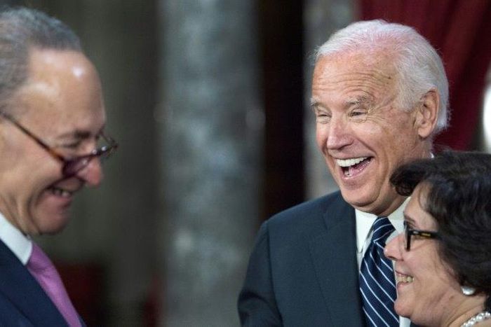 US Senator Charles Schumer, US Vice-President Joe Biden(R) and Iris Schumer laugh during a reenacted swearing-in in Washington, DC